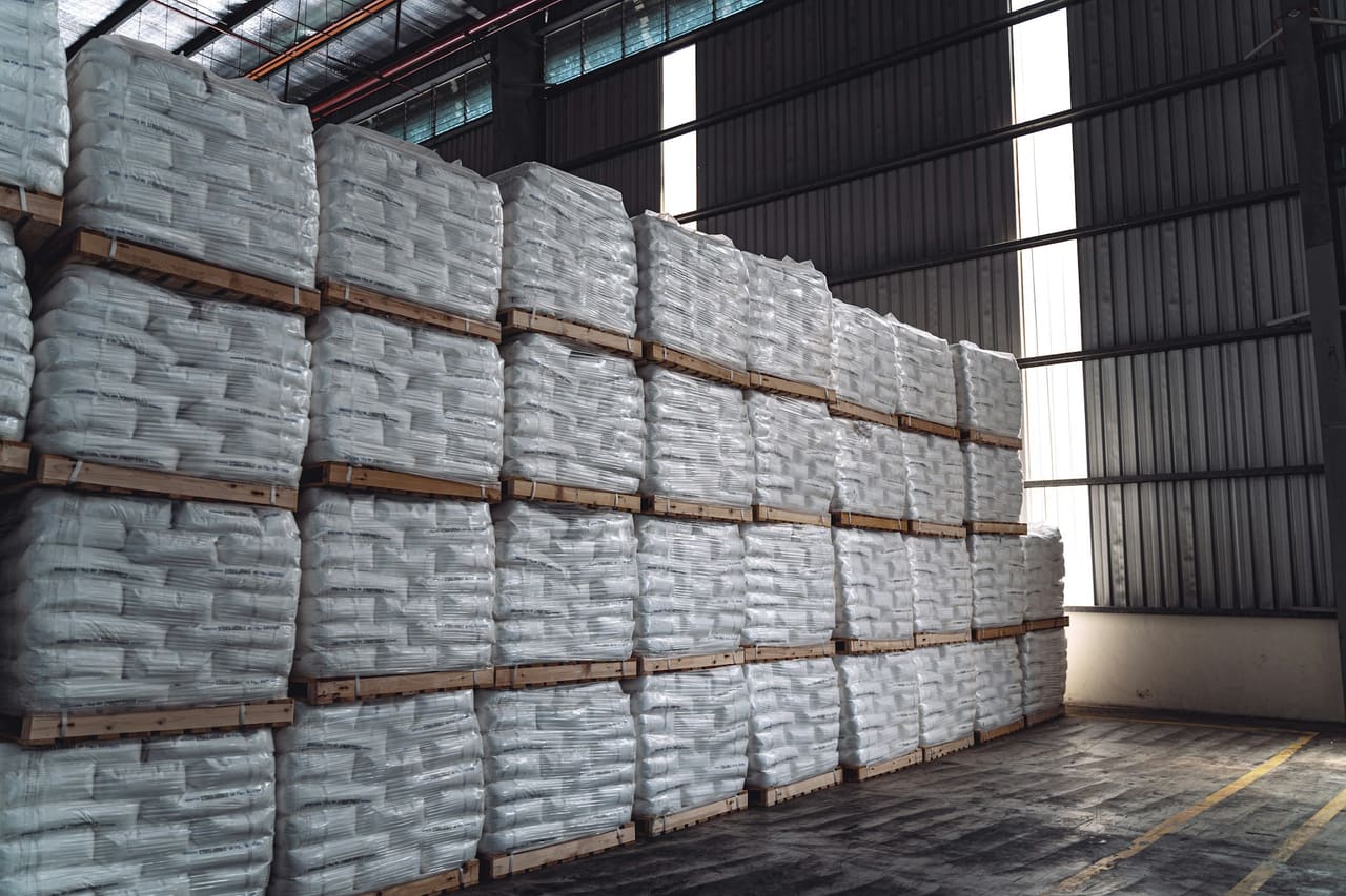 Pallets of bagged fertiliser stacked in a warehouse